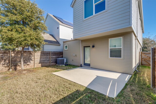 back of house featuring cooling unit, a lawn, and a patio