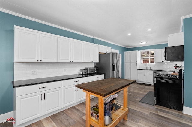 kitchen with stainless steel fridge with ice dispenser, crown molding, white cabinets, and light wood-type flooring