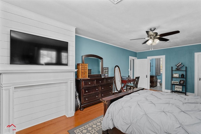 bedroom featuring connected bathroom, crown molding, light hardwood / wood-style flooring, and ceiling fan