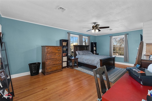 bedroom with multiple windows, wood-type flooring, ornamental molding, and ceiling fan