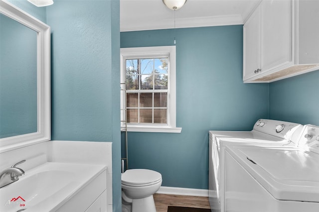 bathroom featuring ornamental molding, vanity, hardwood / wood-style floors, washing machine and dryer, and toilet