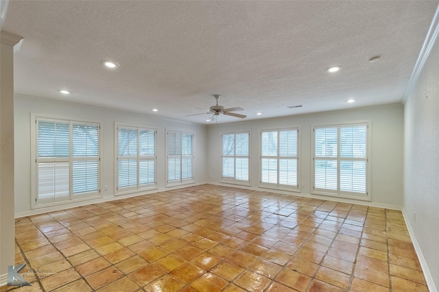 tiled spare room with a wealth of natural light, a textured ceiling, and ceiling fan