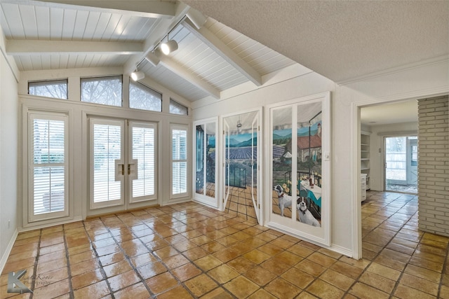 unfurnished sunroom featuring lofted ceiling with beams