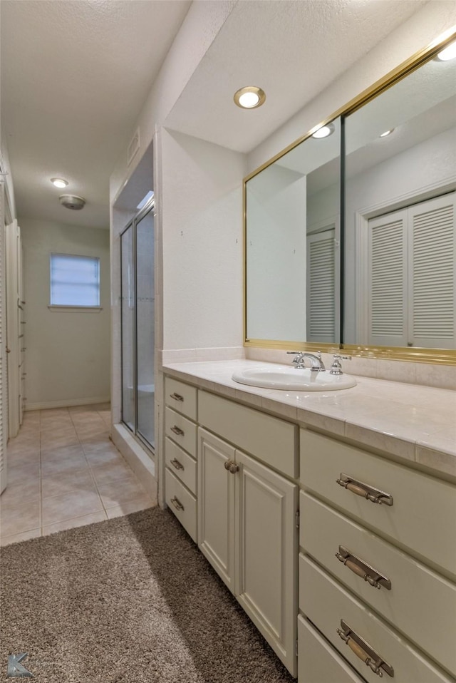 bathroom featuring vanity, tile patterned floors, and a shower with shower door