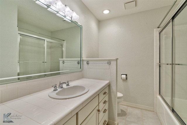 full bathroom with tile patterned flooring, vanity, enclosed tub / shower combo, and toilet