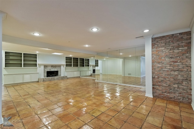 unfurnished living room featuring a tile fireplace, light tile patterned floors, and ornamental molding