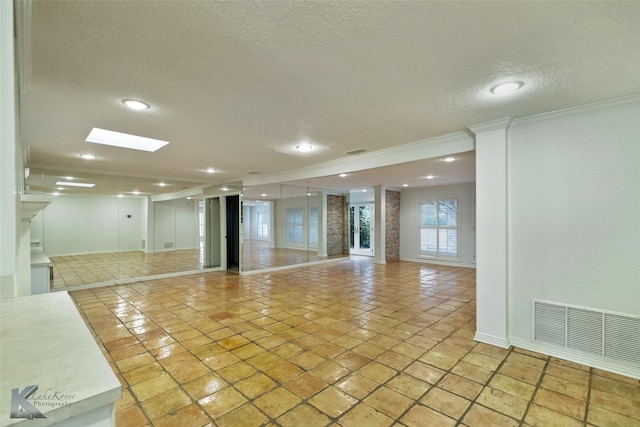 spare room featuring light tile patterned floors, a textured ceiling, and ornamental molding