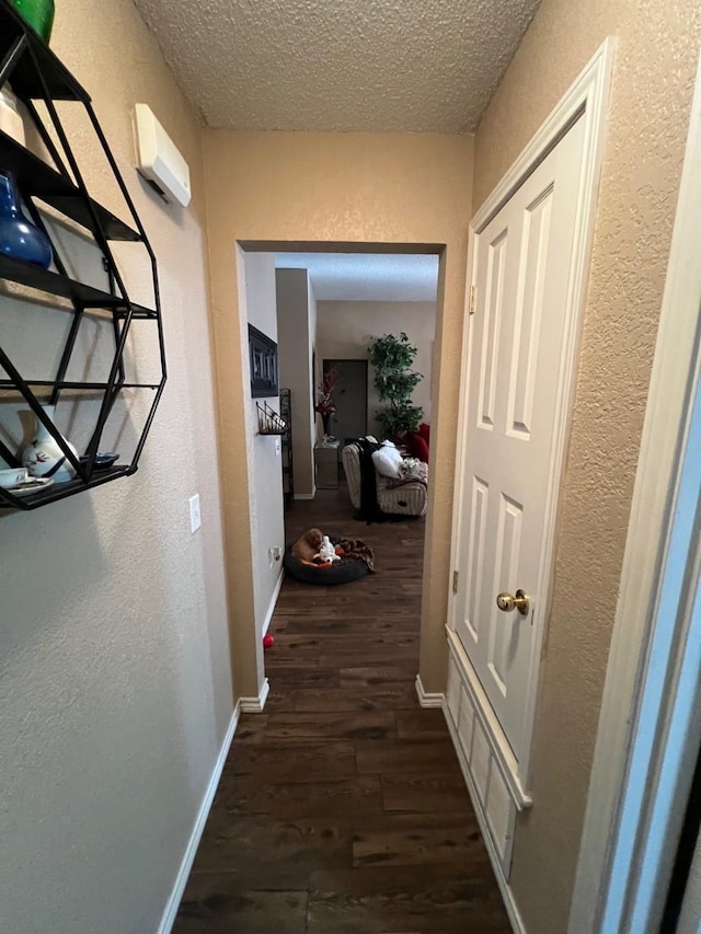 hallway featuring dark hardwood / wood-style floors and a textured ceiling