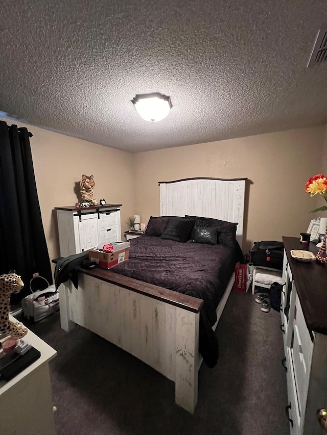 bedroom with a textured ceiling and dark colored carpet