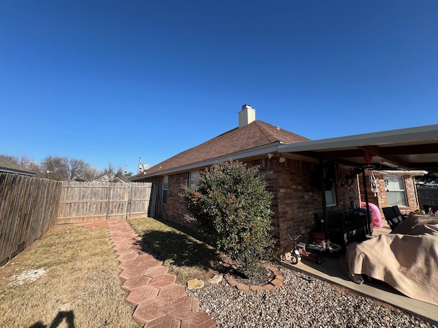 view of side of property with ceiling fan and a patio area