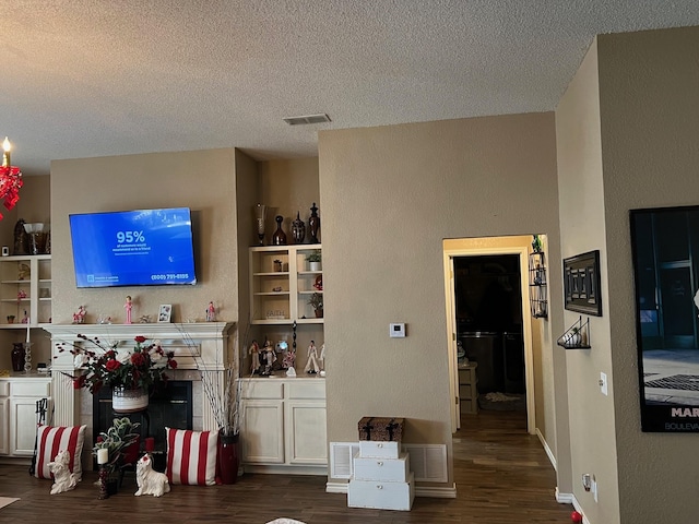 interior space with dark hardwood / wood-style flooring, a textured ceiling, and white cabinets