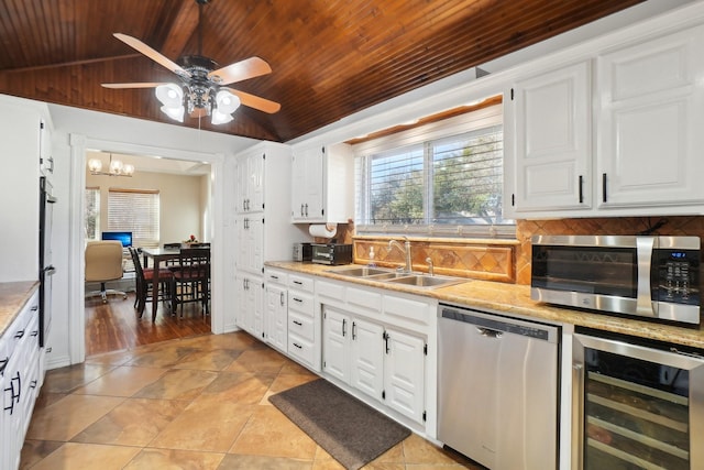 kitchen featuring wine cooler, sink, white cabinetry, stainless steel appliances, and decorative backsplash