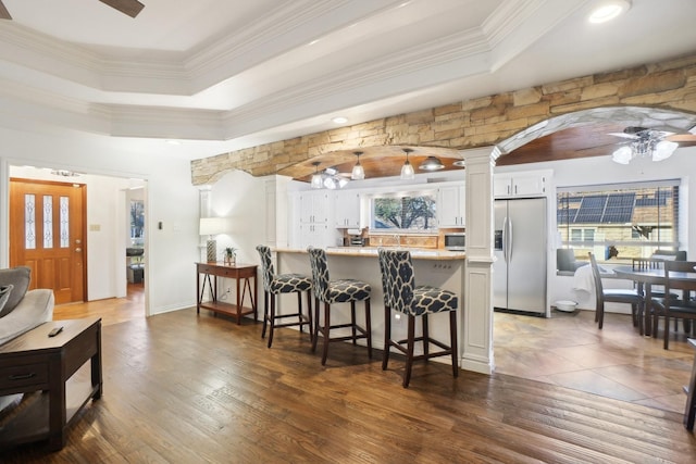 kitchen featuring ornate columns, appliances with stainless steel finishes, kitchen peninsula, ceiling fan, and white cabinets