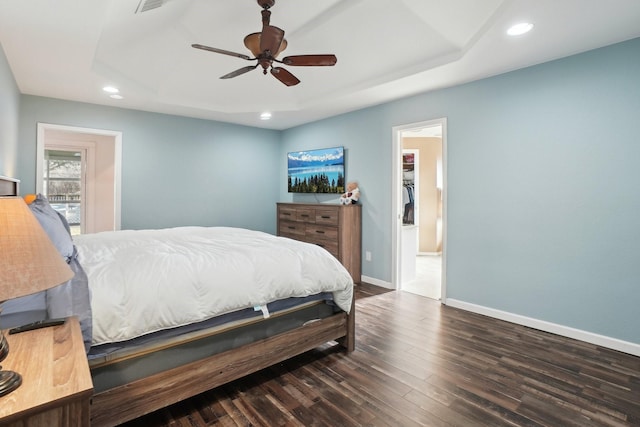 bedroom featuring ceiling fan, dark hardwood / wood-style floors, and a raised ceiling