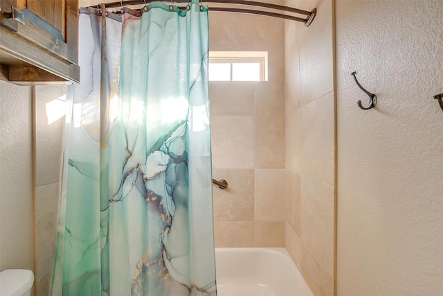 bathroom featuring toilet and shower / bath combo