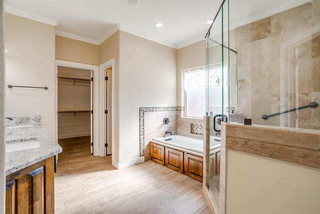 bathroom featuring separate shower and tub, hardwood / wood-style floors, vanity, and ornamental molding