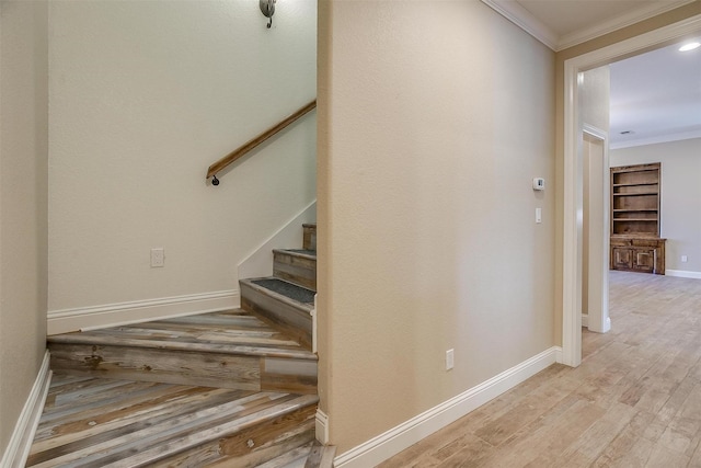 staircase with crown molding and hardwood / wood-style flooring