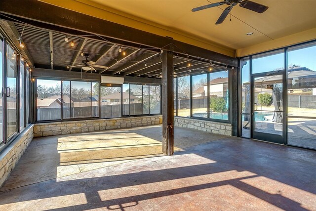 unfurnished sunroom featuring ceiling fan and a healthy amount of sunlight