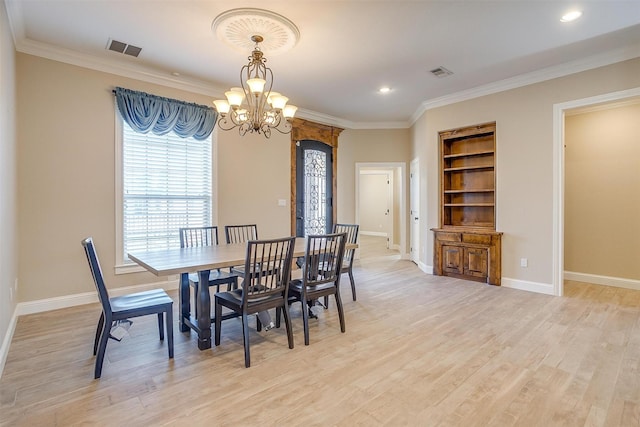 dining area featuring a notable chandelier, built in shelves, light wood-type flooring, and crown molding