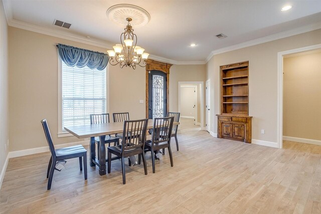 dining room featuring crown molding, a chandelier, and light hardwood / wood-style floors