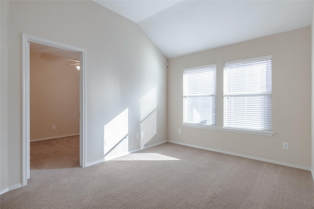 unfurnished room with lofted ceiling and light carpet