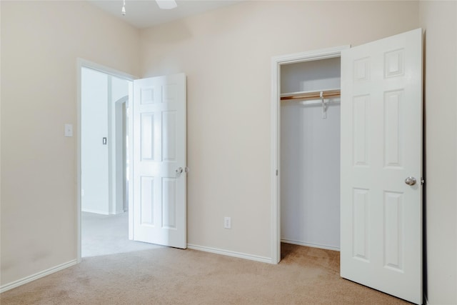 unfurnished bedroom featuring a closet and light carpet