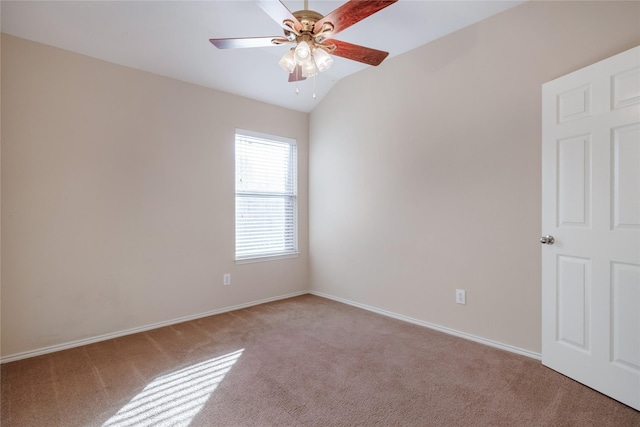 empty room featuring lofted ceiling, light colored carpet, and ceiling fan