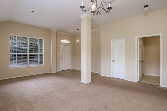 unfurnished room with ornate columns, an inviting chandelier, crown molding, vaulted ceiling, and light carpet