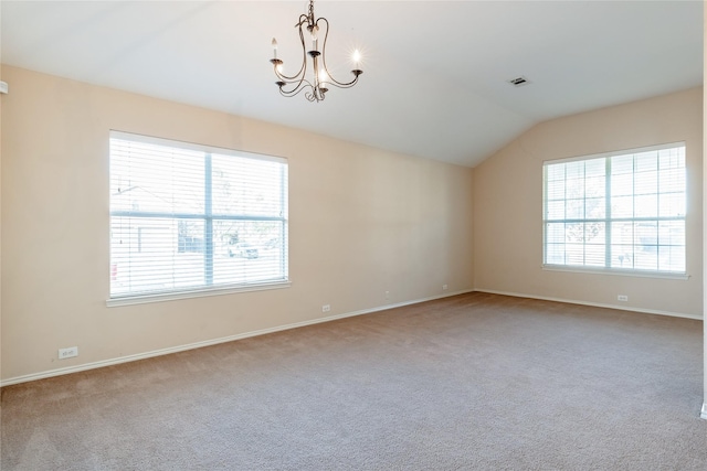 carpeted spare room featuring vaulted ceiling and an inviting chandelier