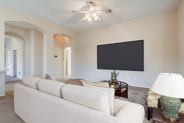 carpeted living room with ceiling fan