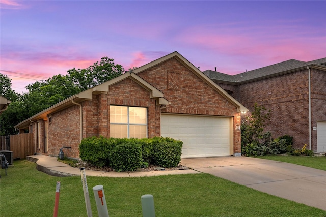 view of front of house featuring a garage and a lawn