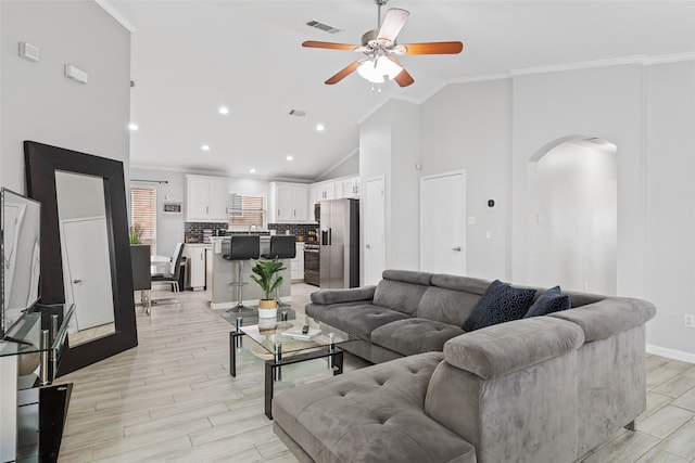 living room with ceiling fan, crown molding, and high vaulted ceiling