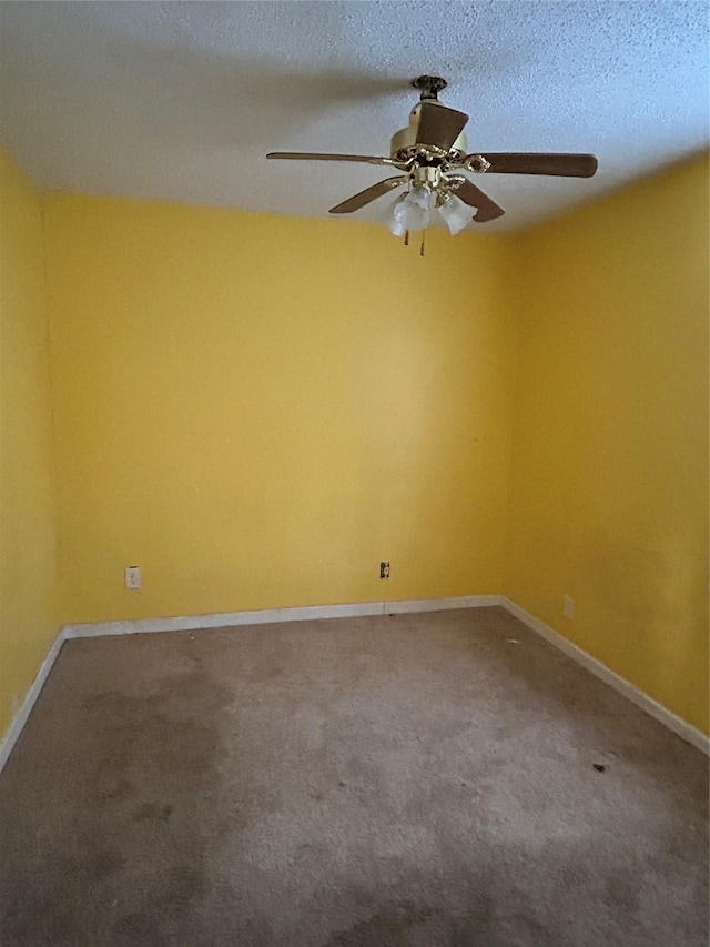 empty room featuring ceiling fan, carpet, and a textured ceiling