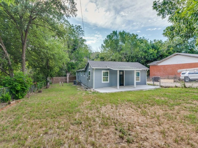 back of house with a lawn and a patio area