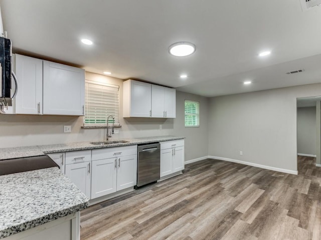 kitchen with dishwasher, white cabinets, sink, light hardwood / wood-style flooring, and light stone counters