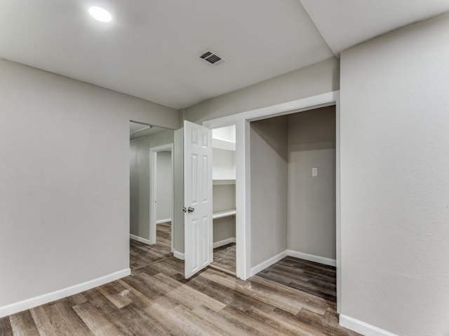 unfurnished bedroom featuring a closet and dark wood-type flooring