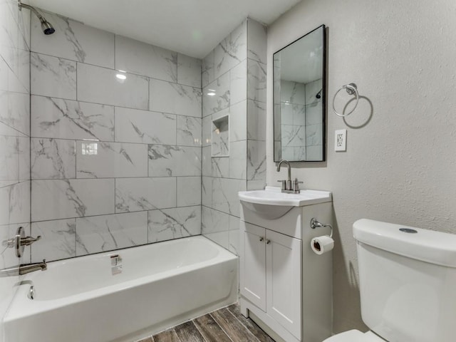 full bathroom with vanity, tiled shower / bath combo, and toilet