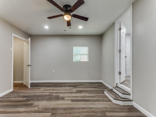 spare room featuring ceiling fan and dark wood-type flooring