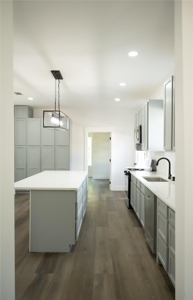 kitchen featuring sink, gray cabinetry, hanging light fixtures, appliances with stainless steel finishes, and a kitchen island