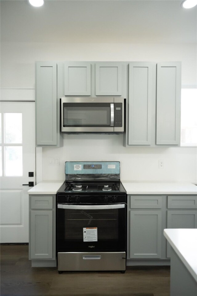 kitchen with dark wood-type flooring, gray cabinets, and appliances with stainless steel finishes