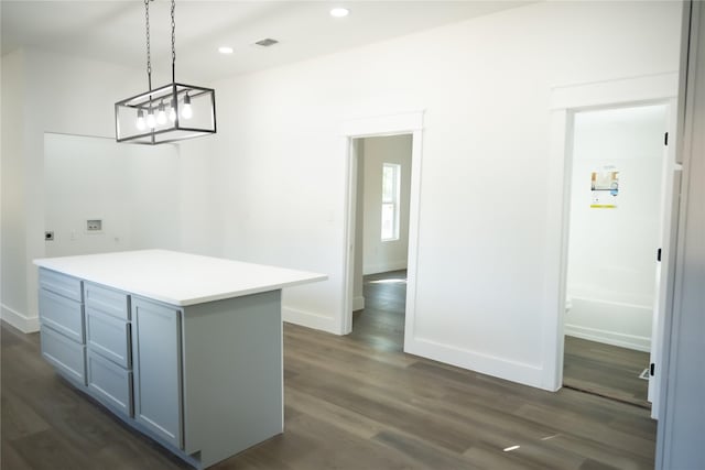 kitchen featuring a kitchen island, dark wood-type flooring, pendant lighting, and gray cabinetry