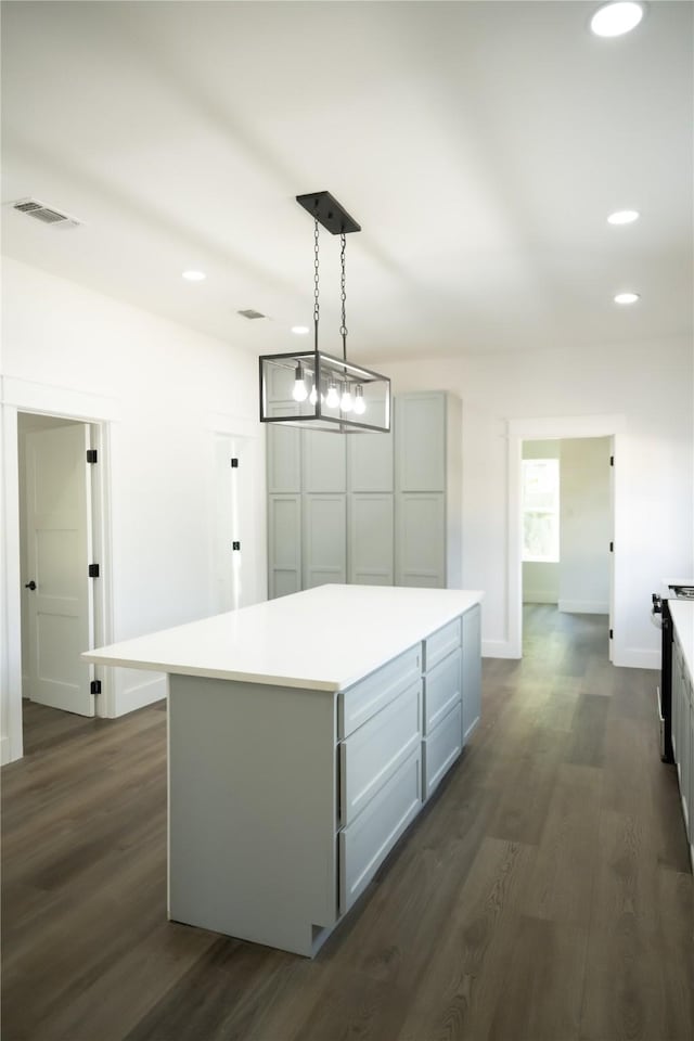 kitchen with dark wood-type flooring, gray cabinetry, hanging light fixtures, a center island, and black / electric stove