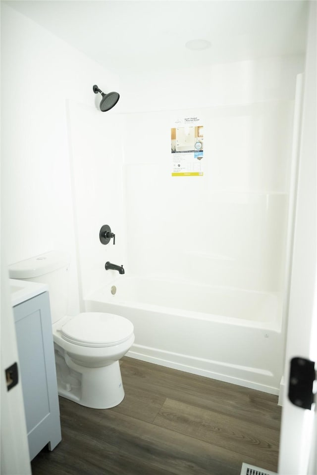 full bathroom with vanity, hardwood / wood-style floors, shower / bathtub combination, and toilet