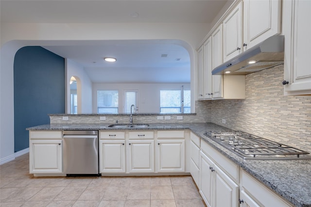 kitchen featuring kitchen peninsula, tasteful backsplash, stainless steel gas cooktop, sink, and white cabinets