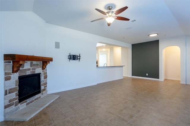 unfurnished living room with ceiling fan, a fireplace, and vaulted ceiling