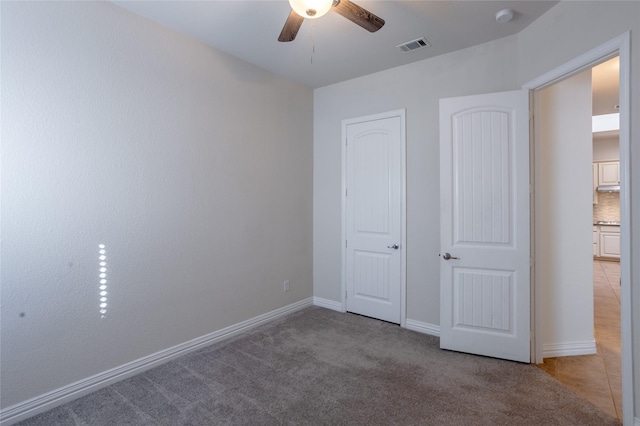 unfurnished bedroom with ceiling fan and light carpet