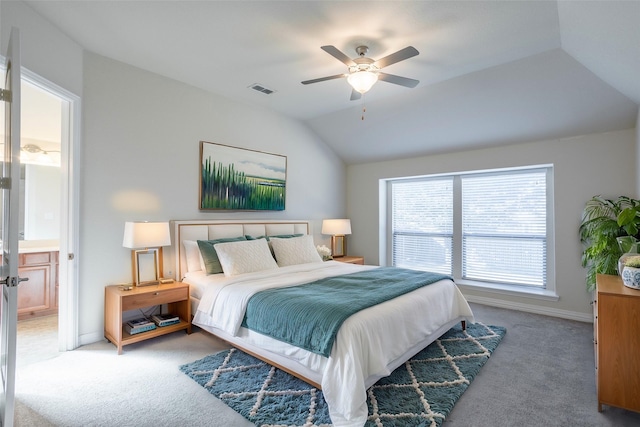 carpeted bedroom with connected bathroom, vaulted ceiling, and ceiling fan