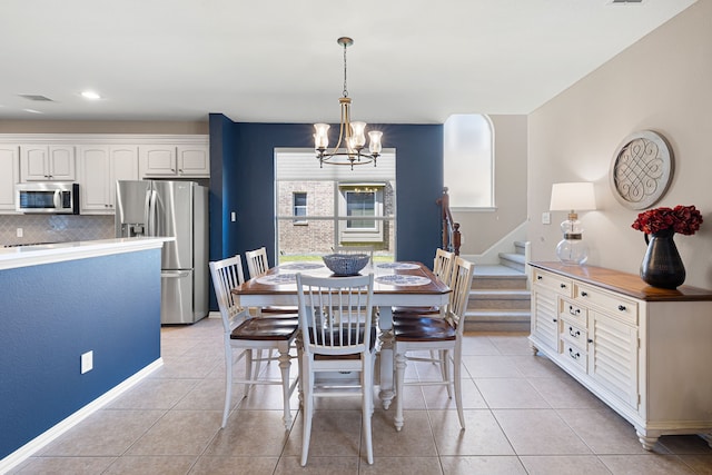 tiled dining space with a notable chandelier