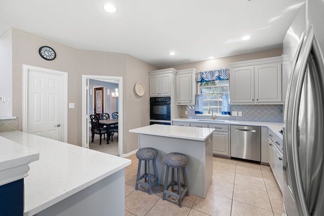 kitchen featuring a kitchen island, white cabinetry, stainless steel appliances, and light tile patterned floors