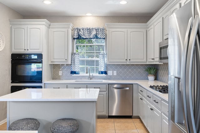 kitchen with white cabinetry, sink, light tile patterned floors, and stainless steel appliances